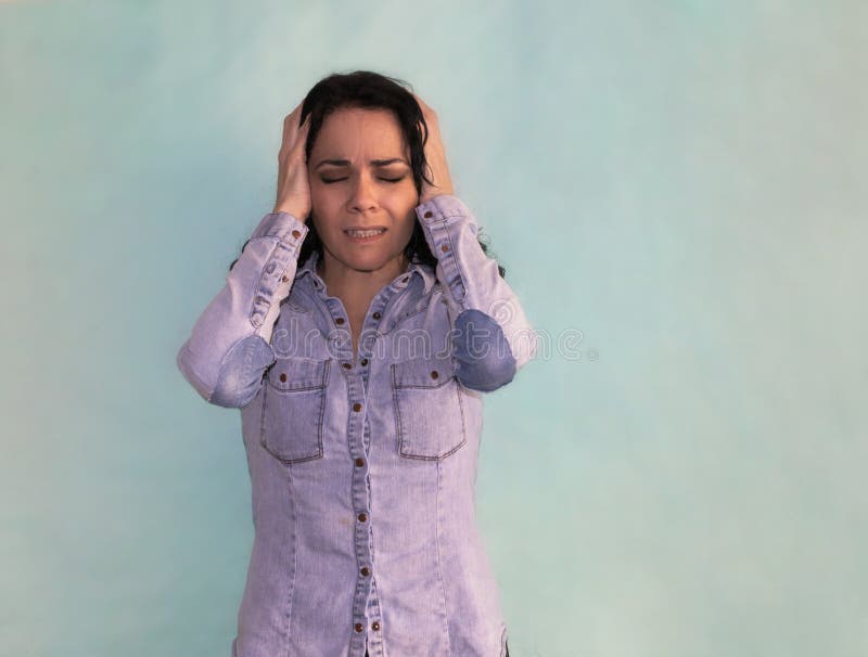 Douleur de femme de brune de mal de tête et migraine désespérée avec des mains sur sa tête photographie stock Douleur de femme de brune de mal de tête et migraine désespérée avec des mains sur sa tête photographie stock