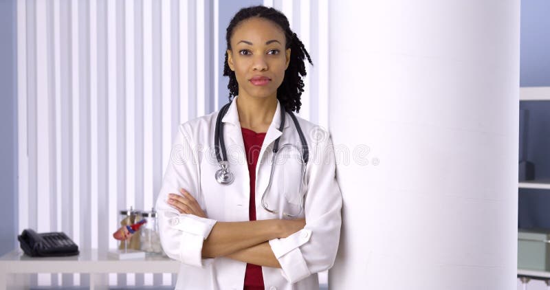 Doutor bem sucedido da mulher negra que está no escritório imagens de stock royalty free Doutor bem sucedido da mulher negra que está no escritório imagens de stock royalty free