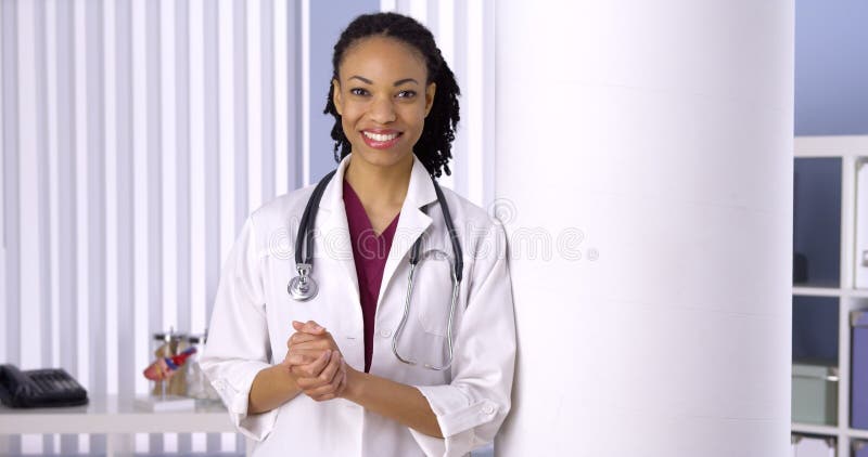Doutor bem sucedido da mulher negra que sorri no escritório foto de stock Doutor bem sucedido da mulher negra que sorri no escritório foto de stock