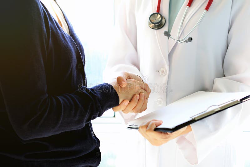 Doutor e paciente fêmea que agitam as mãos, o conceito dos cuidados médicos e do auxílio imagens de stock royalty free Doutor e paciente fêmea que agitam as mãos, o conceito dos cuidados médicos e do auxílio imagens de stock royalty free