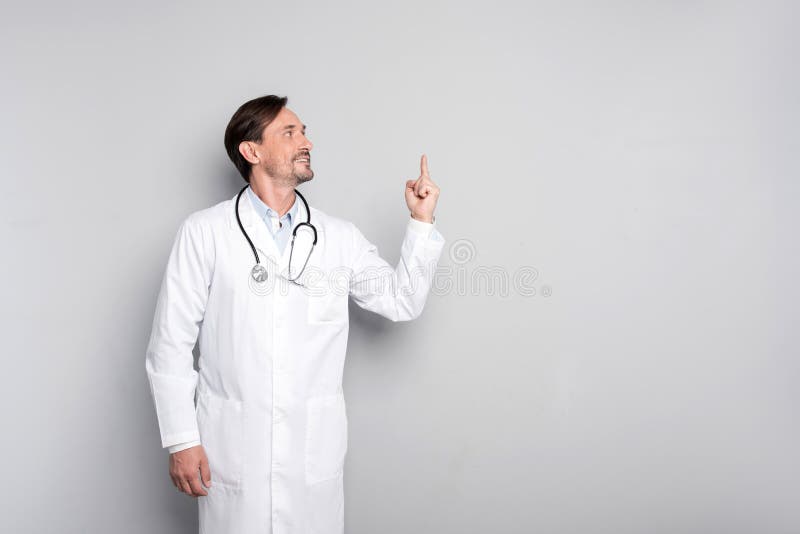Doutor inspirado que aponta seu dedo acima fotografia de stock Doutor inspirado que aponta seu dedo acima fotografia de stock