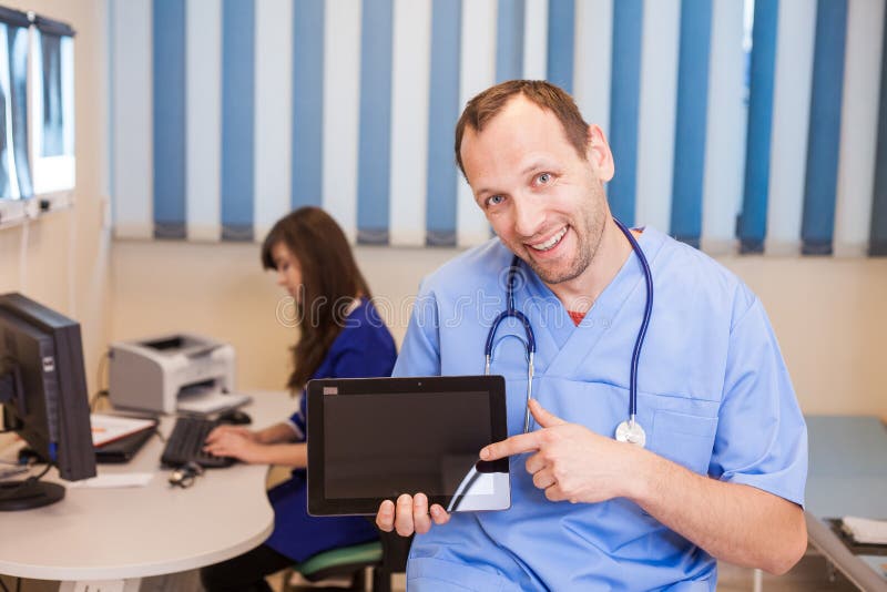 Doutor masculino que usa um tablet pc em um hospital Em um backgrou fotografia de stock Doutor masculino que usa um tablet pc em um hospital Em um backgrou fotografia de stock
