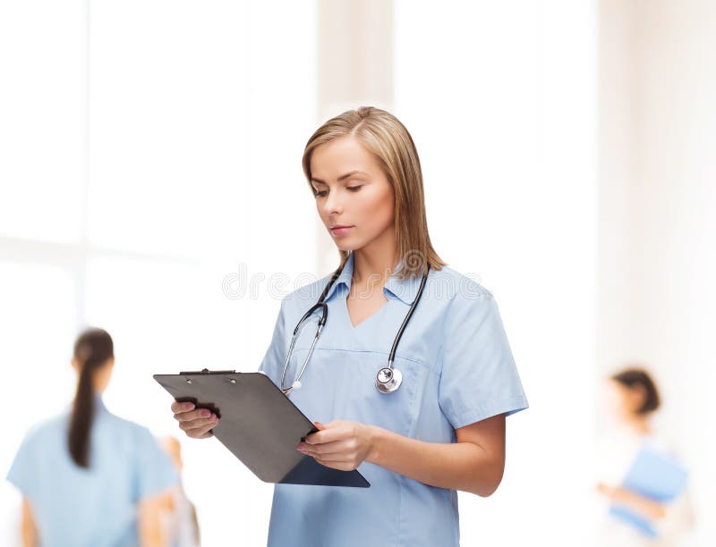 Doutor ou enfermeira fêmea de sorriso com prancheta