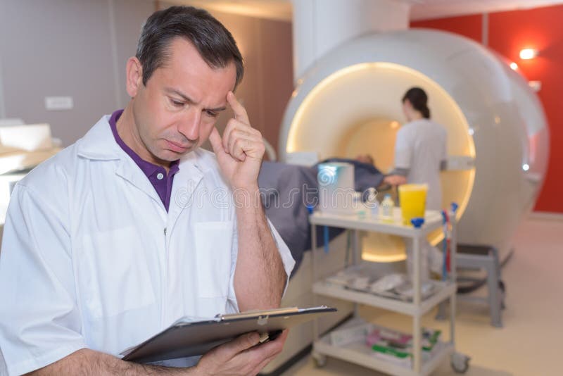 Doutor que guarda o mri do cérebro fotografia de stock royalty free Doutor que guarda o mri do cérebro fotografia de stock royalty free