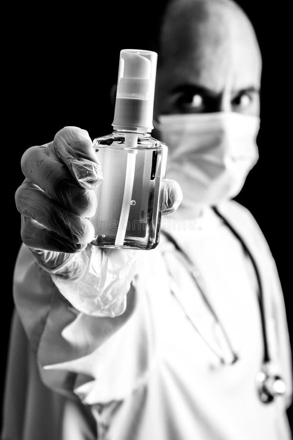 Doutor usando máscara e estetoscópio segura um sanitador manual fotografia de stock Doutor usando máscara e estetoscópio segura um sanitador manual fotografia de stock