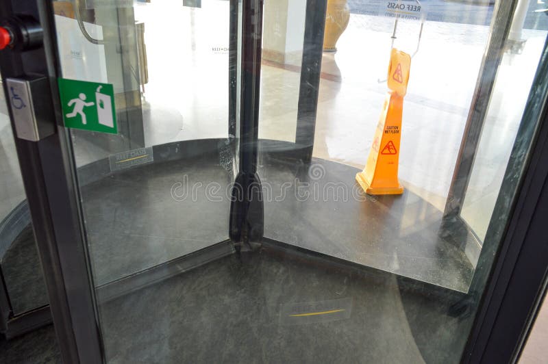 Draaiende het winkelcentrum van de glasdeur de bouw verankerde de drie-deur structuur centrale schacht en roterend teken aan de n royalty-vrije stock afbeeldingen Draaiende het winkelcentrum van de glasdeur de bouw verankerde de drie-deur structuur centrale schacht en roterend teken aan de n royalty-vrije stock afbeeldingen