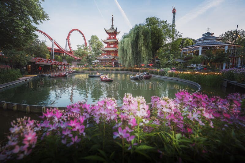 Copenhagen, Denmark - Jun 25, 2019: Dragon Boat lake and the Chinese Tower at Tivoli Gardens Amusement Park - Copenhagen, Denmark