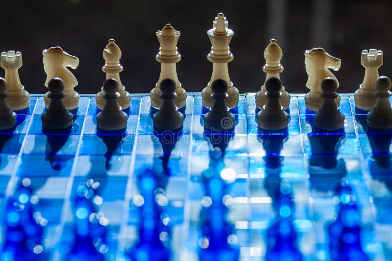 A dramatic chessboard scene with contrasting black and white pieces royalty free stock photography