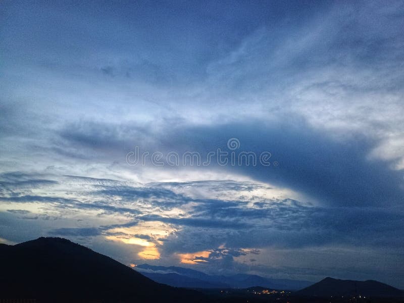 Dramatic Cloudscape Over Mountain Silhouette at Sunset stock photography