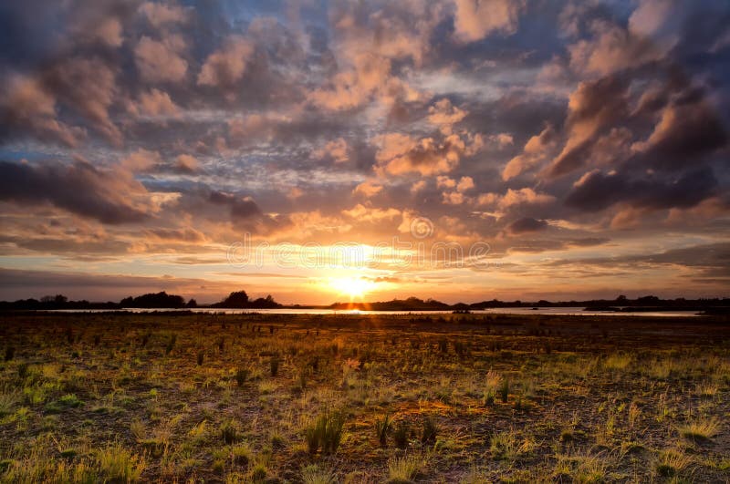 Dramatic cloudscape at sunset over meadow