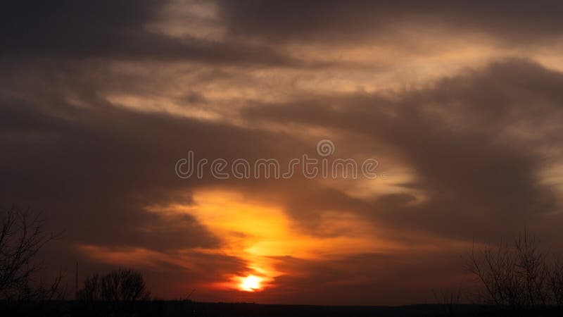 Cloudy sky at sunset over dark urban horizon silhouette stock photography