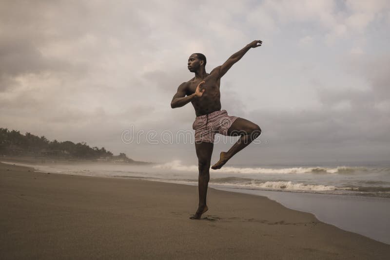 Dramatic contemporary dance choreographer doing ballet beach workout, young attractive and athletic afro black American man royalty free stock image Dramatic contemporary dance choreographer doing ballet beach workout, young attractive and athletic afro black American man royalty free stock image