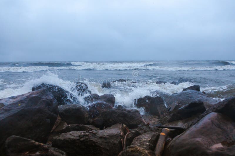 Dramatic foaming splashing waves in stormy weather background. Stormy weather with Dramatic foaming splashing waves as background before rain