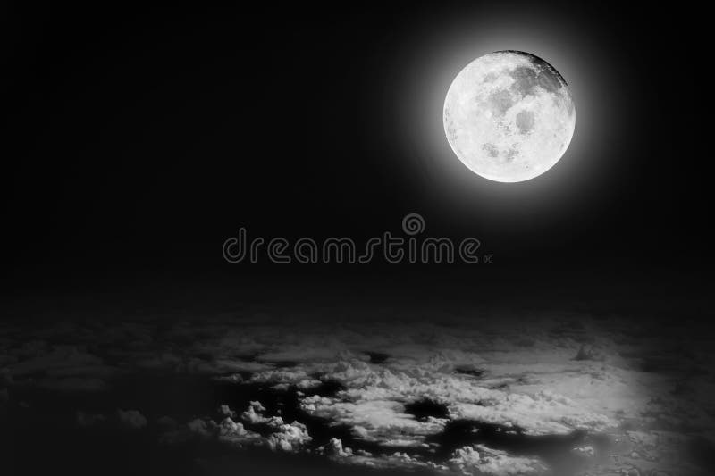 Dramatic image of bright full moon in the night sky background over the white soft clouds. Image use for meteorology and science stock photo