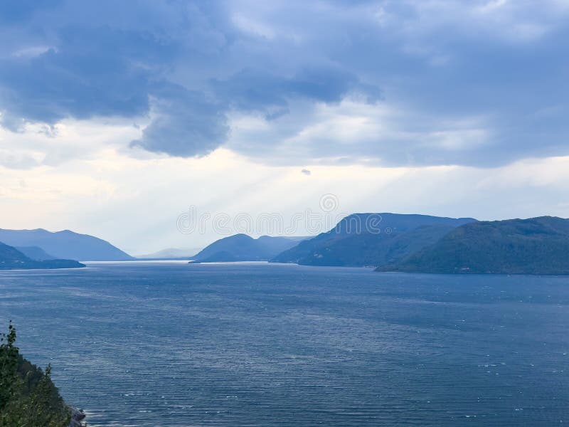 Dramatic landscape of saguenay fjord with sun rays piercing through the cloudy sky, creating a scenic view stock photos