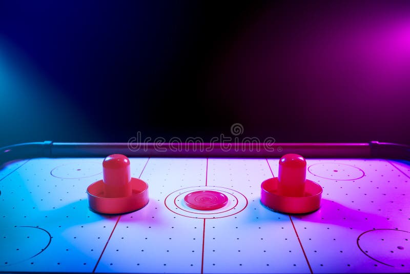 Dramatic Lit Air Hockey Table with Puck and Paddles Stock Photo Image