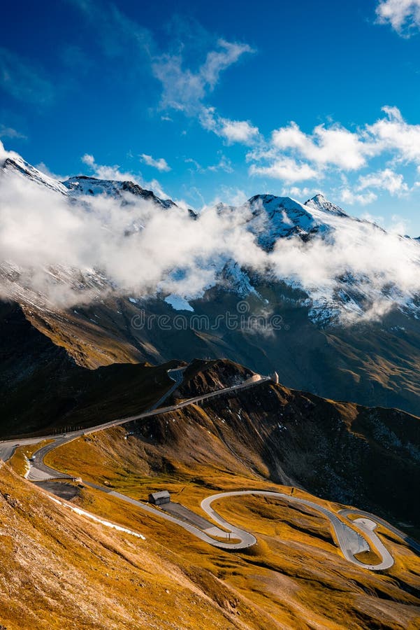 Dramatic Mountains and Clouds with Curvy Serpentine Road in Valley