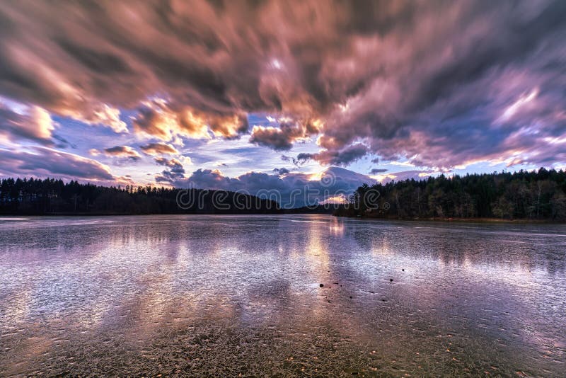 Dramatic sunset at a frozen lake stock photography