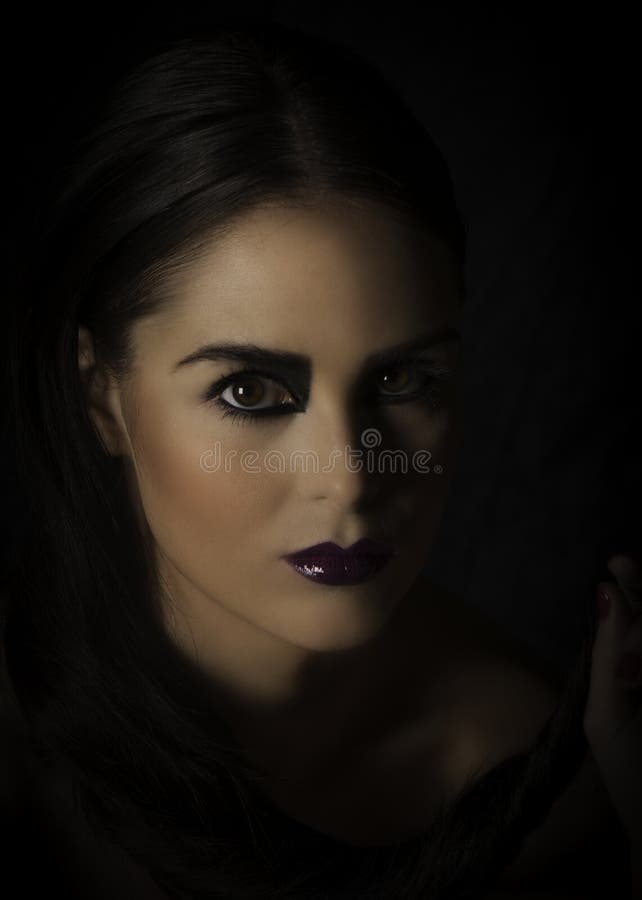 Dramatic Portrait of Dark Haired Beauty with Dark Makeup and Purple ...