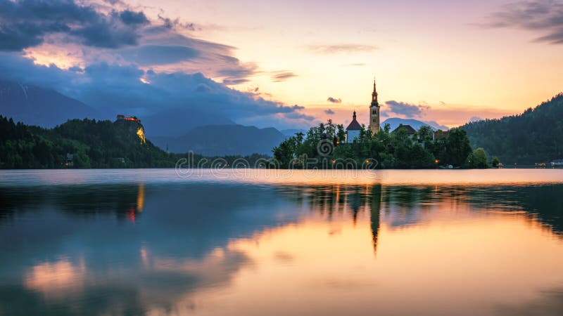 Dramatic sunrise on lake Bled, sunrise view on Bled lake, island, Pilgrimage Church of the Assumption of Maria and Castle with