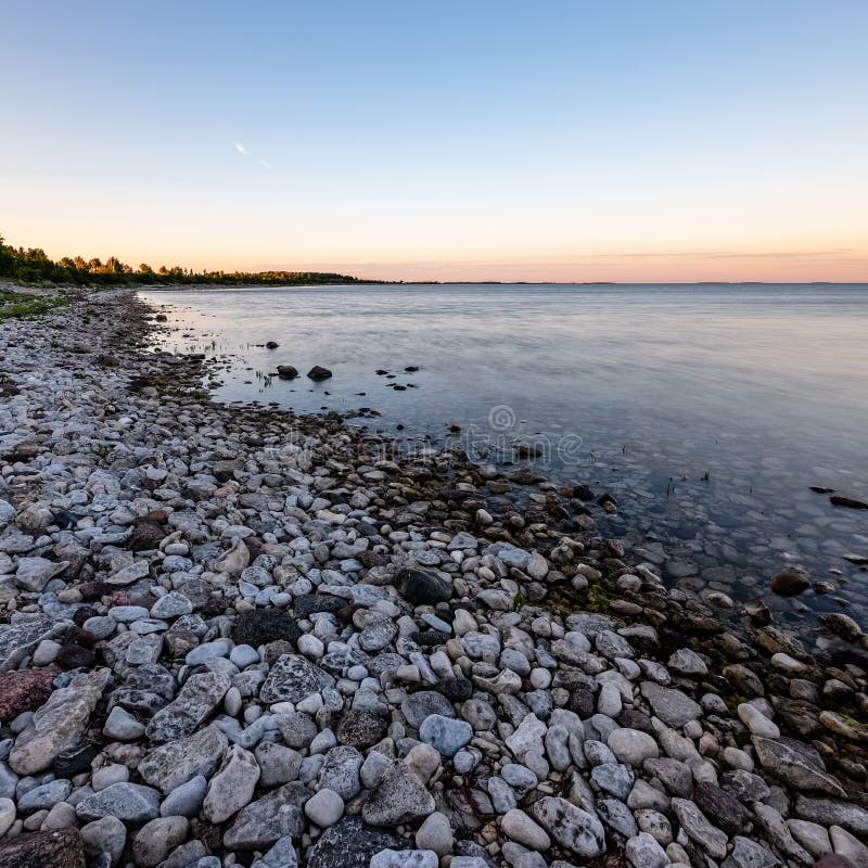 Dramatic Sunrise Over The Baltic Sea With Rocky Beach And Trees Stock