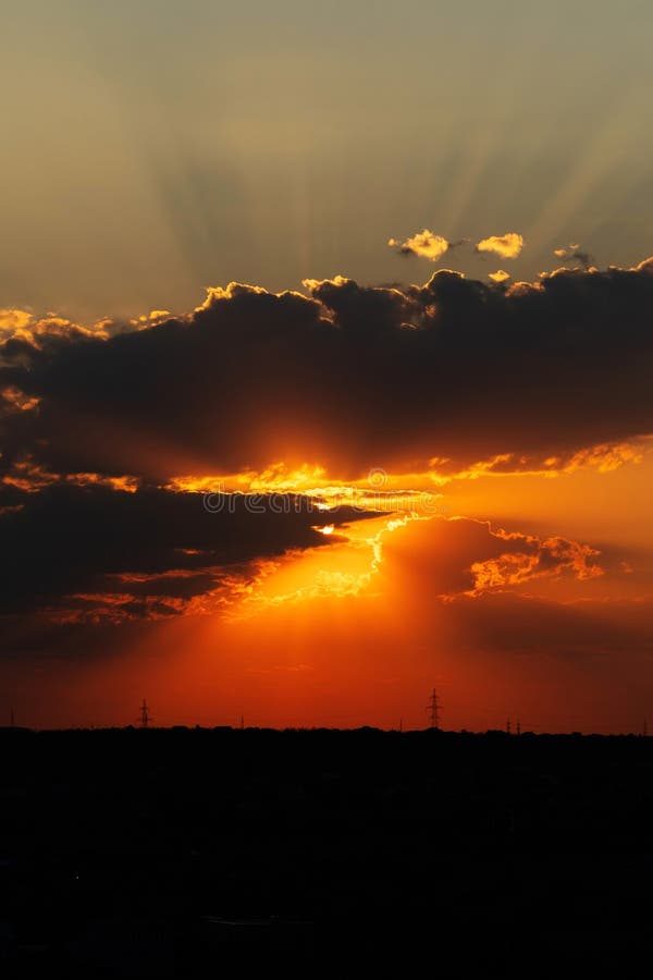 Dramatic sunset with sun rays bursting through thick clouds royalty free stock images
