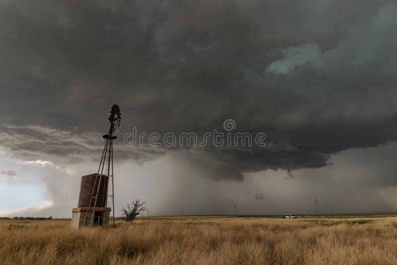 A severe thunderstorm with a windmill in the foreground.