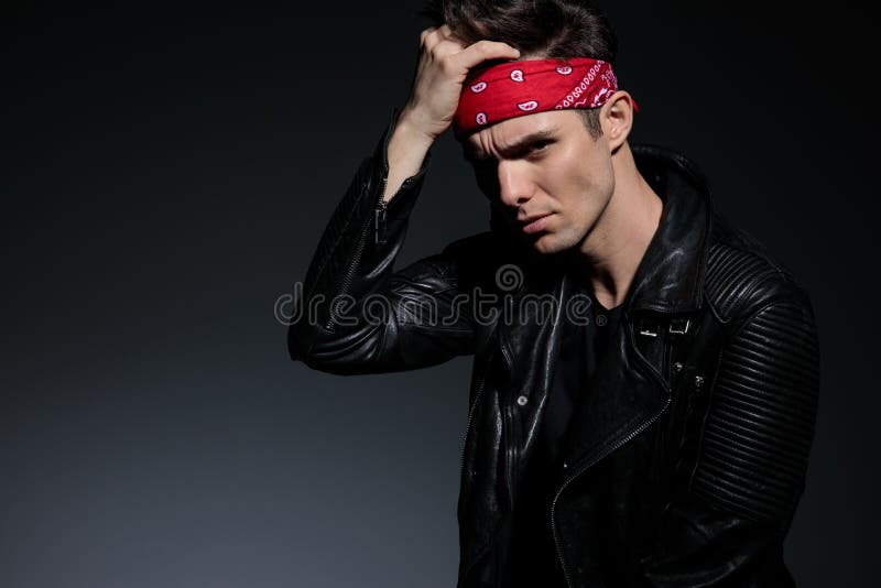 Dramatic young man wearing leather jacket and red bandana