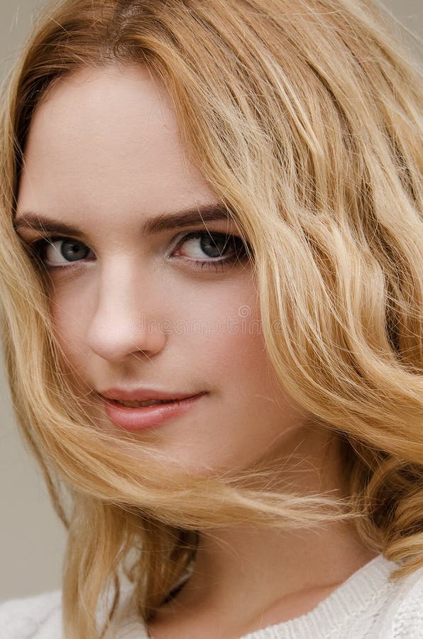 Dramatisk stående av en ung härlig blond kvinna med långt lockigt hår royaltyfri foto Dramatisk stående av en ung härlig blond kvinna med långt lockigt hår royaltyfri foto