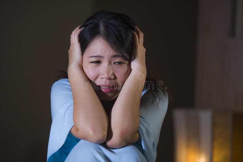 Dramatisk stående av ungt härligt och ledset asiatiskt japanskt gråta för kvinna som är desperat på säng som är vaken på nattlida royaltyfri fotografi Dramatisk stående av ungt härligt och ledset asiatiskt japanskt gråta för kvinna som är desperat på säng som är vaken på nattlida royaltyfri fotografi