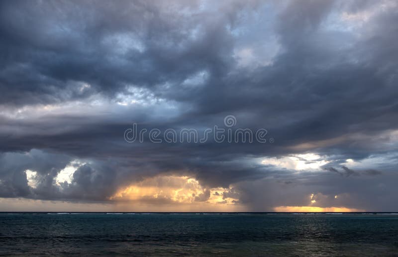 Dramatisk himmel när solen går upp bakom regnmoln arkivbilder