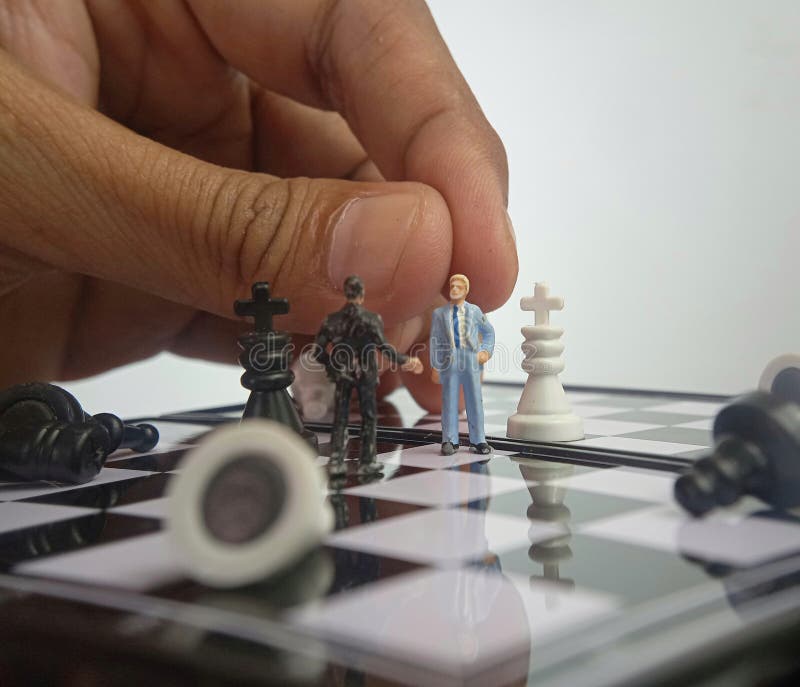 Dramática ilustración para la guerra fotográfica o el concepto de situación política, dos mini figura de pie, mano hombre moviend imagen de archivo Dramática ilustración para la guerra fotográfica o el concepto de situación política, dos mini figura de pie, mano hombre moviend imagen de archivo