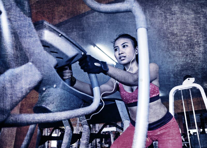 Dramático edite da mulher asiática suado 'sexy' nova que treina duramente no gym usando a máquina pedaling elíptica foto de stock royalty free Dramático edite da mulher asiática suado 'sexy' nova que treina duramente no gym usando a máquina pedaling elíptica foto de stock royalty free