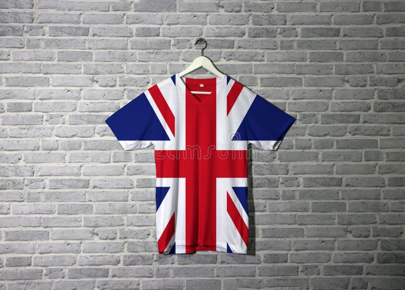 Union jack flag on shirt and hanging on the wall with brick pattern wallpaper. Cross of Saint Andrew counterchanged with the Cross of Saint Patrick, over all the Cross of Saint George. Union jack flag on shirt and hanging on the wall with brick pattern wallpaper. Cross of Saint Andrew counterchanged with the Cross of Saint Patrick, over all the Cross of Saint George