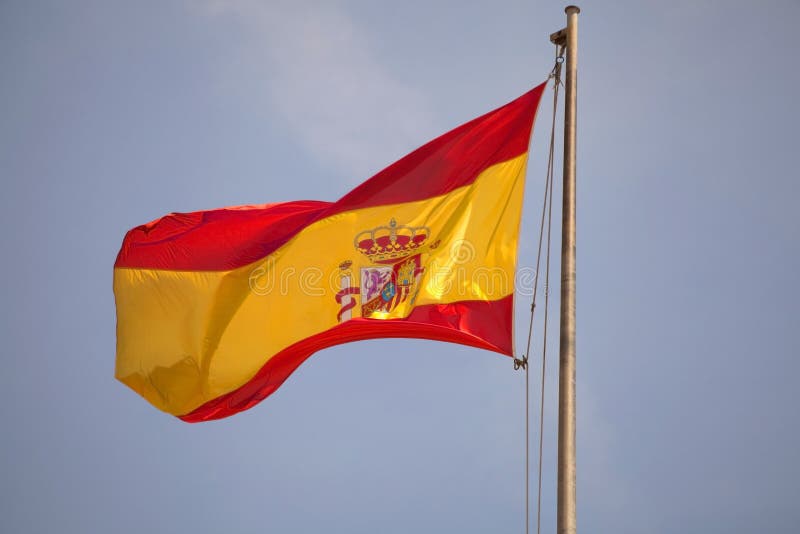 Drapeau de l'Espagne ondulant en ciel bleu. photo stock Drapeau de l'Espagne ondulant en ciel bleu. photo stock