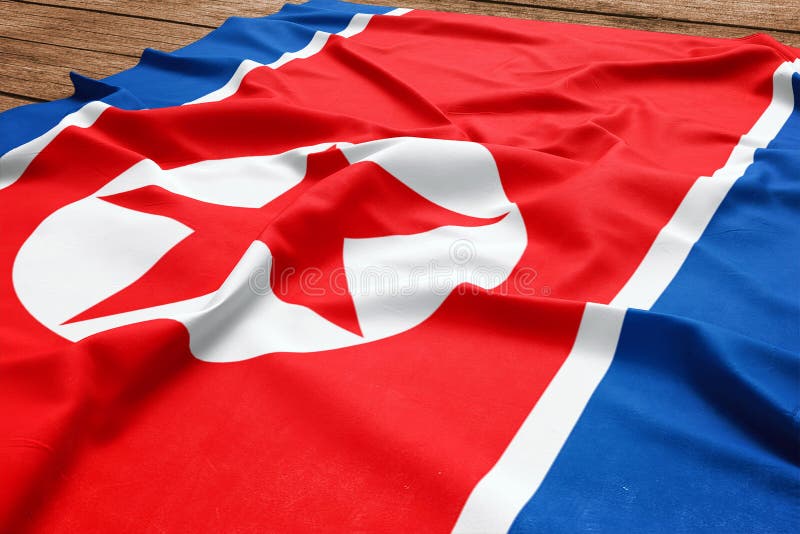 Drapeau de la Cor?e du Nord sur un fond en bois de bureau Vue sup?rieure de drapeau cor?en du nord en soie image stock Drapeau de la Cor?e du Nord sur un fond en bois de bureau Vue sup?rieure de drapeau cor?en du nord en soie image stock
