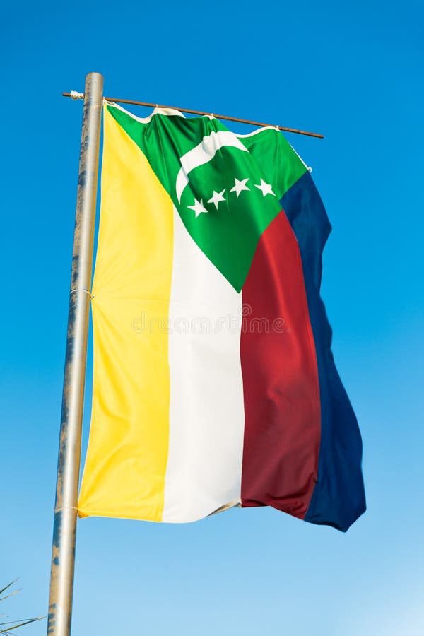 Waving National flag of Comoros on flagpole. Waving National flag of Comoros on flagpole