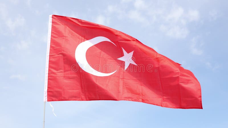 Drapeau national turc avec étoile blanche et croissant sur flagpole sur fond de ciel bleu