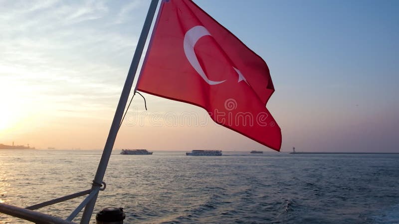 Drapeau rouge national turc avec lune et étoile agitant le vent contre le coucher du soleil