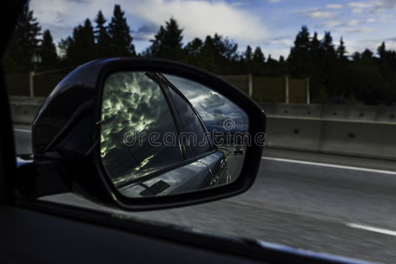 Drastische Wolke in der Reflexion im Seitenansichtspiegel des Autos lizenzfreie stockfotos Drastische Wolke in der Reflexion im Seitenansichtspiegel des Autos lizenzfreie stockfotos