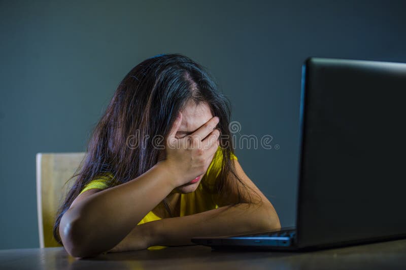 Drastisches Porträt des jungen traurigen und erschrockenen Frauenbedeckungsgesichtes mit den Händen betont und gesorgt, die Lapto stockfotografie Drastisches Porträt des jungen traurigen und erschrockenen Frauenbedeckungsgesichtes mit den Händen betont und gesorgt, die Lapto stockfotografie