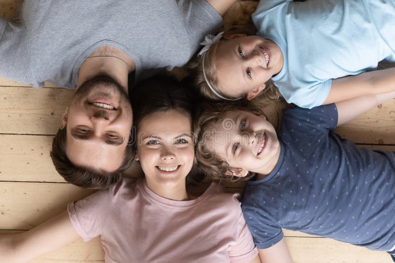 Draufsicht der glücklichen Familie mit den Kindern, die auf dem Boden liegen stockfotos