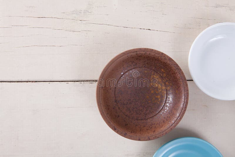 Draufsicht der leeren bunten Platte setzte an weiße hölzerne Tabelle lizenzfreies stockfoto Draufsicht der leeren bunten Platte setzte an weiße hölzerne Tabelle lizenzfreies stockfoto