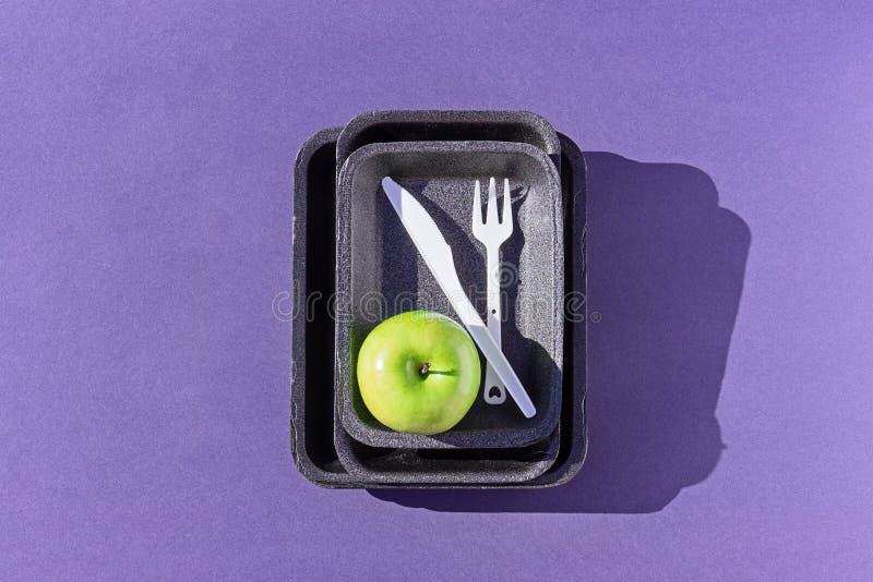 Draufsicht einer leeren Kunststoffschale mit gr?nem Apfel auf Purpur lizenzfreies stockbild Draufsicht einer leeren Kunststoffschale mit gr?nem Apfel auf Purpur lizenzfreies stockbild
