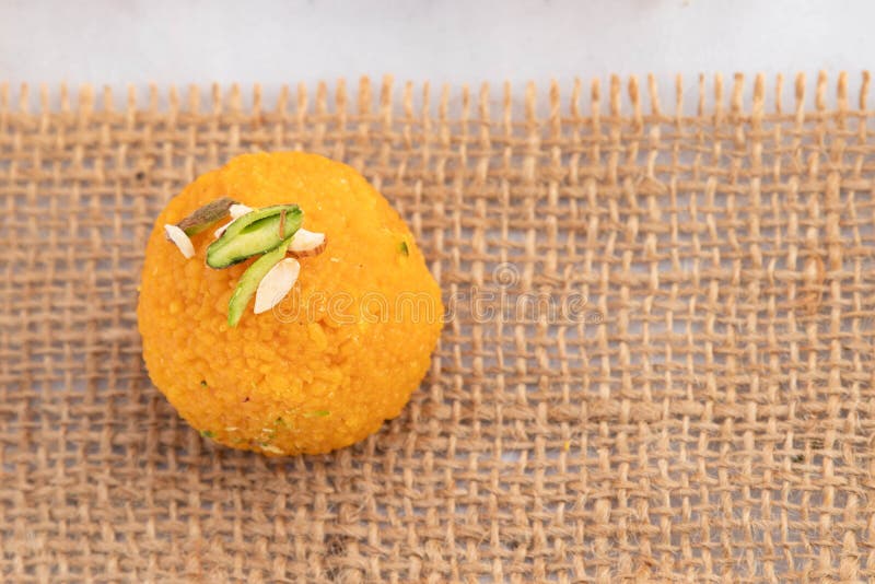 Draufsicht einteiliger indischer Mithai Motichoor ladoo oder Motichur laddu indischer süßer Mithai auf Jute Burlap Stoff. Meetha L stockbild