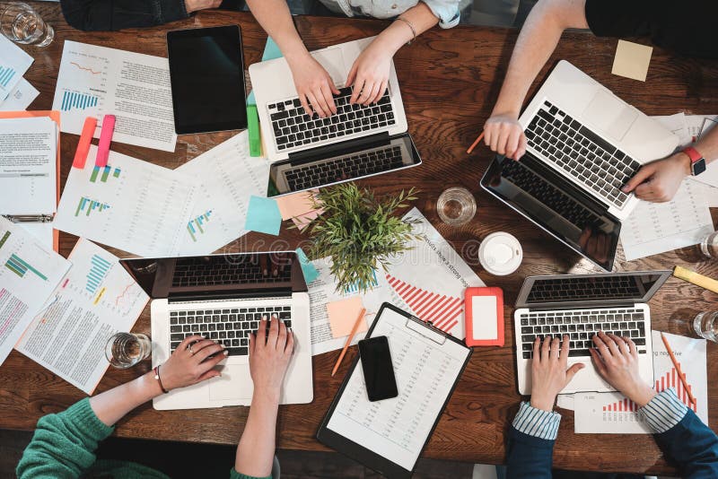 Draufsicht von jungen coworking Leuten arbeiten an Laptops und Papierdokumenten Gruppe Studenten, die Laptop während sittin verwe lizenzfreies stockfoto Draufsicht von jungen coworking Leuten arbeiten an Laptops und Papierdokumenten Gruppe Studenten, die Laptop während sittin verwe lizenzfreies stockfoto