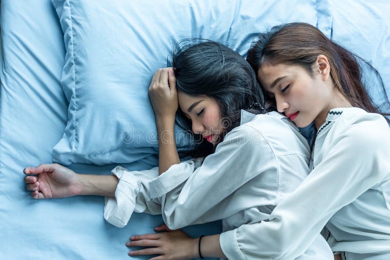 Draufsicht von zwei Asiatinnen, die zusammen auf Bett schlafen Lesbisches lo