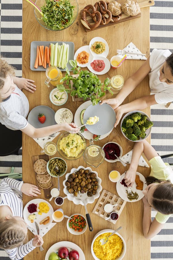 Draufsicht über die Kinder, die gesundes Lebensmittel während Freund ` s birthda essen lizenzfreies stockbild Draufsicht über die Kinder, die gesundes Lebensmittel während Freund ` s birthda essen lizenzfreies stockbild