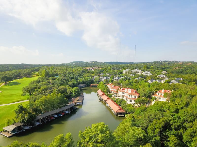 Aerial view hillside luxury mansions lake overlook with boat storage cover, golf course, green trees in Austin, Texas, USA. Aerial view hillside luxury mansions lake overlook with boat storage cover, golf course, green trees in Austin, Texas, USA