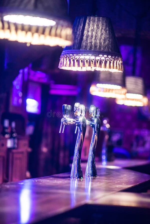 Draught Beer Tap in a Bar in purple light close